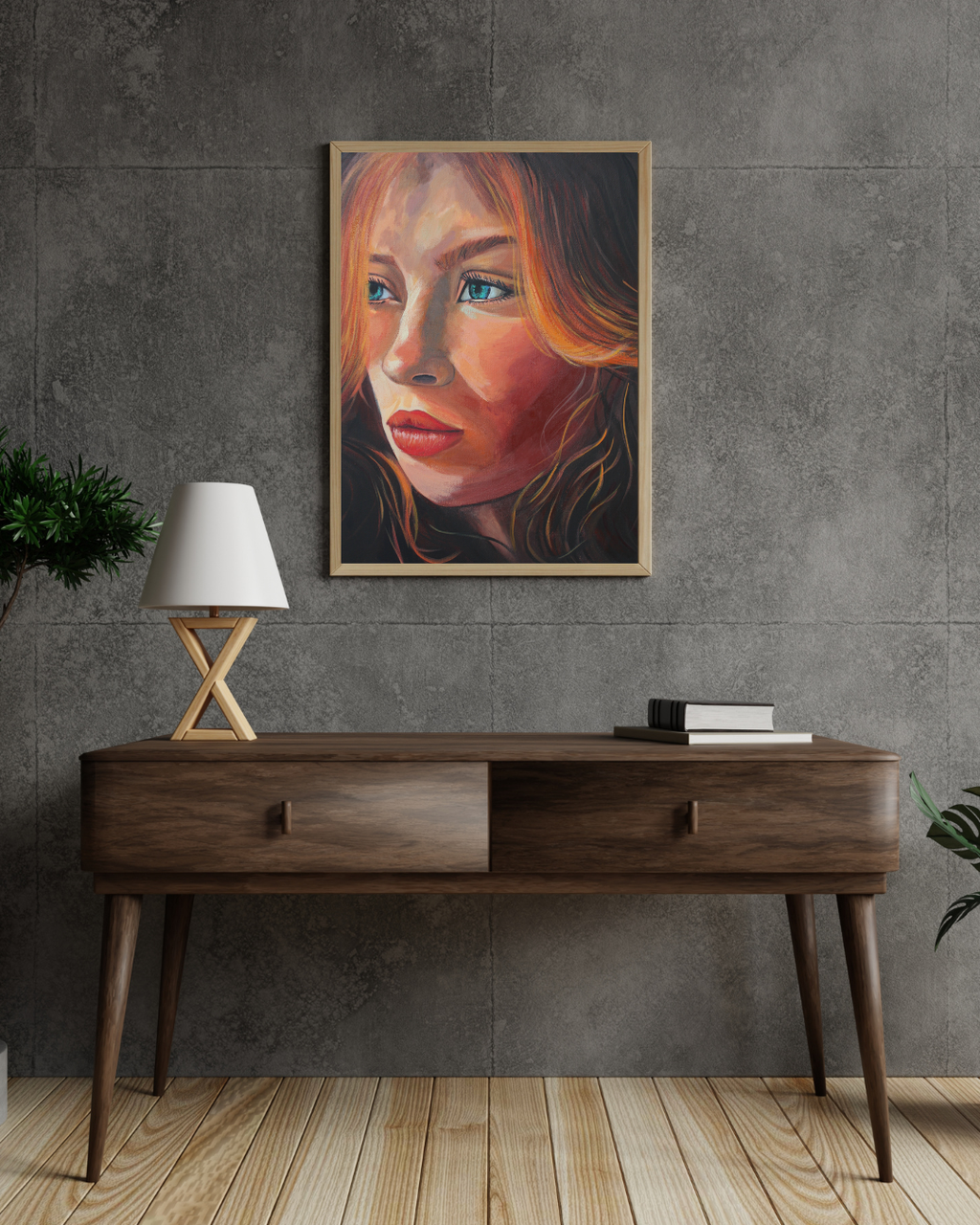 A framed portrait painting of a woman with warm orange and red hair, blue eyes, and red lips, hanging on a textured gray concrete wall above a mid-century modern wooden console table with a lamp and books.