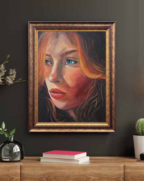 A framed portrait painting of a woman with red hair and blue eyes, displayed on a dark wall above a wooden console table with books and small plants.