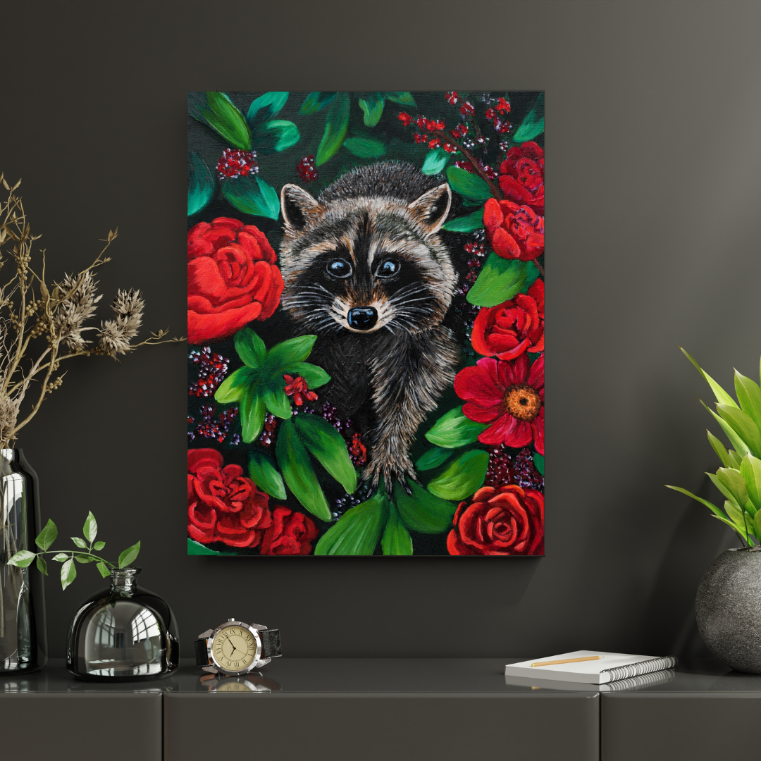 A square wall art print or canvas featuring a raccoon surrounded by red roses and green leaves, displayed on a dark gray wall above a console table with decorative objects.